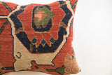 Antique Bijar rug pillow close-up, showing dense terracotta, navy, and beige patterns.