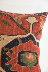 Persian Bijar rug fragment pillow: terracotta, indigo, olive green, and beige geometric pattern.