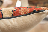 Close-up of antique Bijar pillow side, revealing hand-knotted geometric pattern and black zipper.