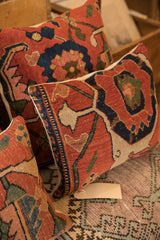 Intricate patterns of a Persian Bijar rug fragment pillow, with rich red, blue, and ivory.