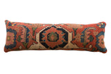Storied antique Persian Bijar rug fragment pillow, deep red and indigo geometric motifs.