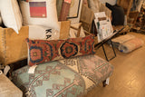 Antique Persian Bijar rug fragment pillow, featuring aged rust and deep blue geometric pattern.