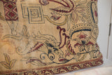 Antique Persian Kerman pillow close-up featuring mythological labyrinth motif and flowering vines on beige.