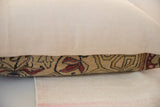 Pillow's side view highlighting the antique Persian Kerman fragment's red floral pattern.