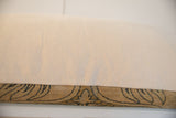 Vintage rug fragment pillow side, light backing fabric, and textured antique Kerman pattern.