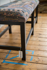Sturdy ebony-stained wooden leg and frame supporting the vintage Turkish rug bench seat.