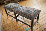Full profile of the reclaimed Turkish rug bench on its sturdy, dark-stained wooden frame.