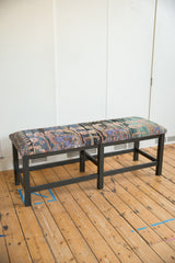 Full profile of a vintage Turkish rug bench featuring a colorful, patterned seat on a dark wooden frame.
