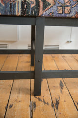 Sturdy construction detail of the vintage rug bench's ebony-stained wooden base.