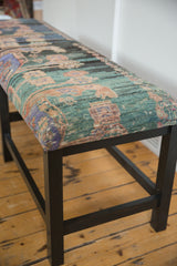 Corner view of the reclaimed rug bench with textured vintage Turkish upholstery on a dark wood frame.