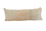 Distressed vintage Turkish Oushak hand-knotted lumbar pillow in faded peach and muted green.