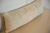 Faded peach, sage, and cream hand-knotted texture of a distressed lumbar pillow.