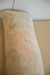 Distressed texture and pale hues on a vintage rug fragment lumbar pillow.