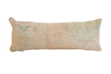 Hand-knotted vintage rug fragment lumbar pillow, faded pale peach and light green.