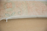 Side view of vintage Oushak lumbar pillow with faded peach pattern and zipper.