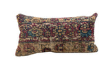 Vintage Rug Fragment Pillow featuring aged ruby, sapphire, and tan floral motifs, 11x23 inches.