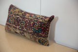 Vintage Kerman rug fragment pillow with intricate curvilinear pattern in deep red and blue.