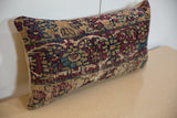 Vintage Kerman rug fragment pillow, showing worn red, blue, and beige motif detail.