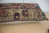 Close-up of vintage rug fragment pillow showing aged pile texture and zippered edge.