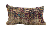 Antique Kerman rug fragment pillow with a weathered geometric pattern in red, blue, and tan.