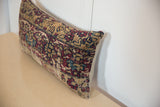 Side profile of a vintage rug fragment pillow showing its textured pile and seam detail.