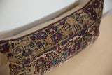 Angled close-up of the storied texture and low pile on a vintage rug fragment pillow.