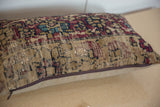 Brown zipper and neutral backing fabric on the bottom edge of a vintage rug pillow.