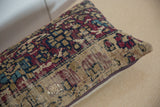 Angled view of the vintage rug pillow, highlighting the time-worn texture and visible foundation.