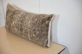 Close-up of the vintage rug fragment pillow's distressed, time-softened texture and muted tones.