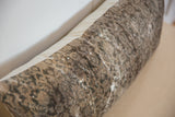 Distressed hand-knotted Malayer rug fragment pillow with worn pile and muted brown tones.