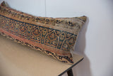Angled close-up of intricate Kerman patterns in blue, red, and beige on vintage lumbar pillow.