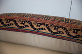 Side view of the vintage Kerman fragment pillow, displaying intricate border and zipper.