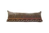 Vintage Kerman rug fragment lumbar pillow featuring blue, rust, and beige palmette motifs.