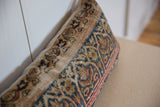 Side detail of vintage Kerman rug fragment pillow, showing faded patterns and worn texture.
