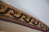 Vintage Kerman rug fragment pillow edge showing gold and navy serpentine motif, zipper.