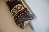 Close-up of the textured wool pile on the corner of a vintage rug lumbar pillow.