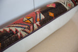 Close-up of the zippered seam on the vintage rug pillow, joining it to a woven ivory backing.