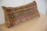 Intricate gold, teal, and red Persian Kerman motifs on the vintage hand-knotted rug fragment pillow.