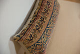 Detailed hand-knotted Kerman rug fragment featuring muted blue, red, and tan floral motifs.