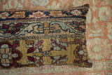 Turtle-like cartouche and floral motifs on the ochre gold ground of an antique Kerman pillow.
