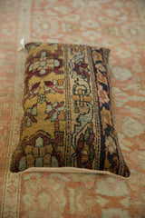Angled view of an antique Kerman pillow highlighting its lustrous wool and floral cartouche design.