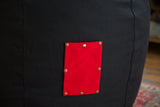 Bright red swappable cotton pocket with metal snaps on the black hemp bean bag.