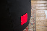 Swappable red cotton pocket with brass studs on the black hemp canvas chair.