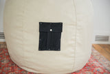 Natural hemp fabric texture and black swappable pocket detail on the bean bag chair.