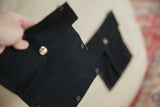 Black cotton swappable pocket detail with shiny metal and matte black snap fasteners.