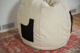 Hemp bean bag chair's textured canvas and attached black swappable pocket.