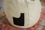 Durable seam and swappable black side pocket on the hemp canvas bean bag chair.