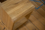 Close-up of the mitered corner and natural grain texture on the solid oak nightstand top.