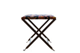 Rug fragment footstool with dark blue, red, yellow patterned vintage seat on folding base.