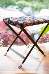 Industrial fold-out metal base with unique twisted feet on the rug footstool.